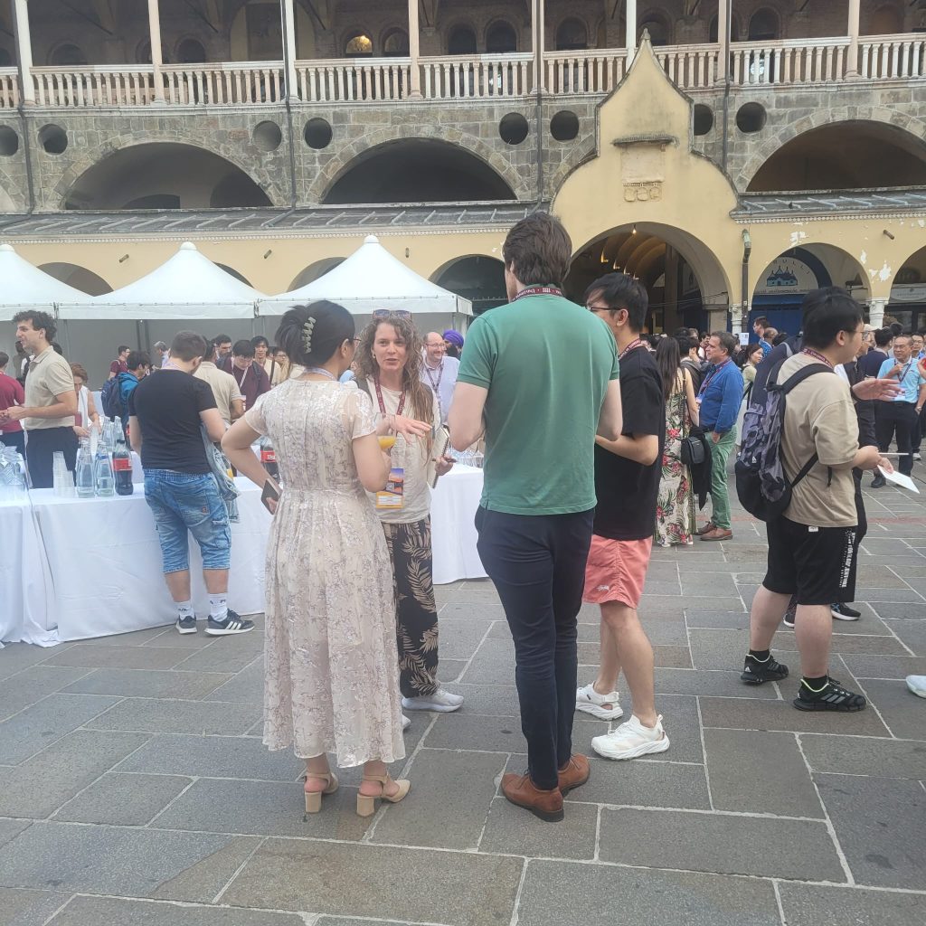 TIB postdoctoral researcher Lauren Snyder chats with SIGIR attendees at the conference welcome reception held at Piazza Della Frutta in Padua. Photo credit: Ricardo Perez Alvarez